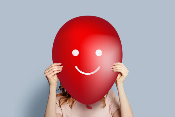 girl holding balloon with smiling smiley, happy face. Happy people, happiness pleasure joy of life - Photo, Image