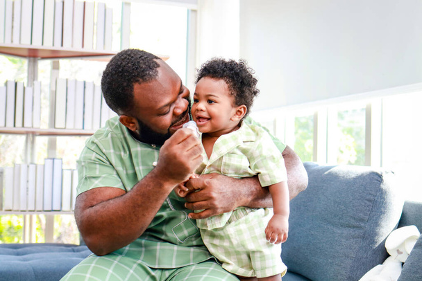 Retrato de un feliz padre e hijo afroamericano en la casa. Concepto familiar. - Foto, imagen