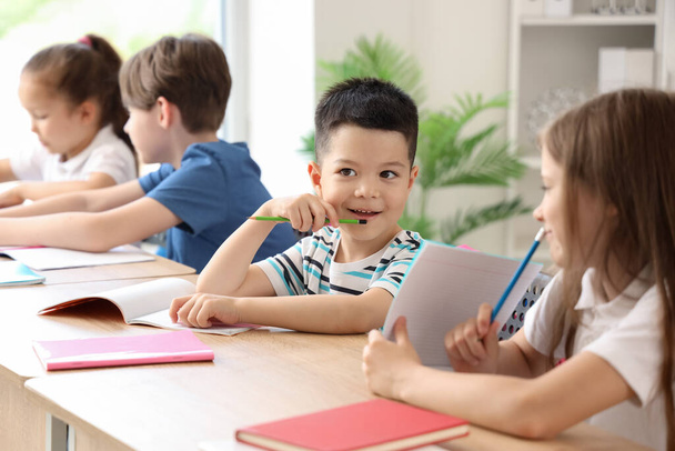 Kleiner Schüler mit Unterricht im Klassenzimmer - Foto, Bild