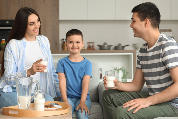 自宅で牛乳を飲んでいる両親と小さな男の子 - 写真・画像