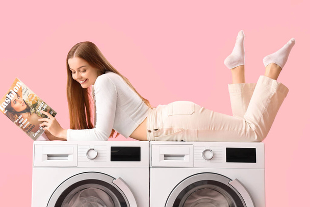 Όμορφη νεαρή γυναίκα ξαπλωμένη στα πλυντήρια και διαβάζοντας περιοδικό σε ροζ φόντο - Φωτογραφία, εικόνα