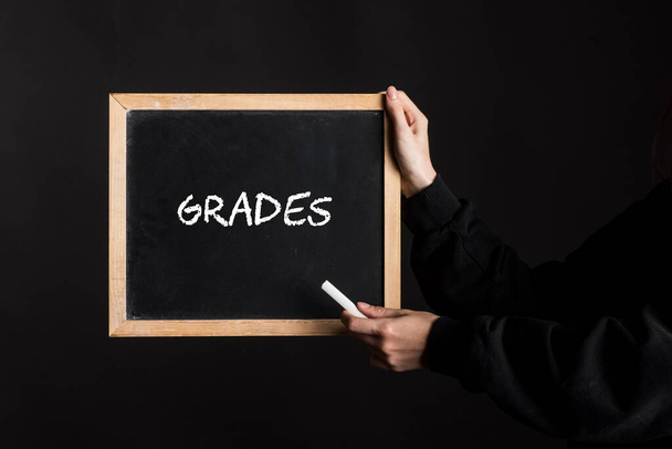 μια πινακίδα μαυροπίνακα με τη λέξη Grades γραμμένο σε αυτό - Φωτογραφία, εικόνα
