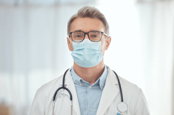 Man, portrait and doctor with face mask in hospital for medical services, surgery and wellness consulting. Male surgeon, mature therapist and healthcare manager working with safety ppe in clinic. - Photo, Image