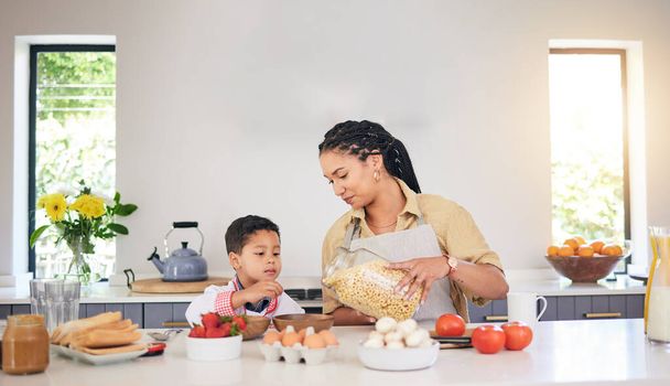 Ontbijt, familie en een moeder en kind koken, bakken of helpen met eten in de keuken. Huis, eten en een jongen kind en een jonge moeder onderwijs tijdens de lunch of voor het diner samen terwijl honger. - Foto, afbeelding