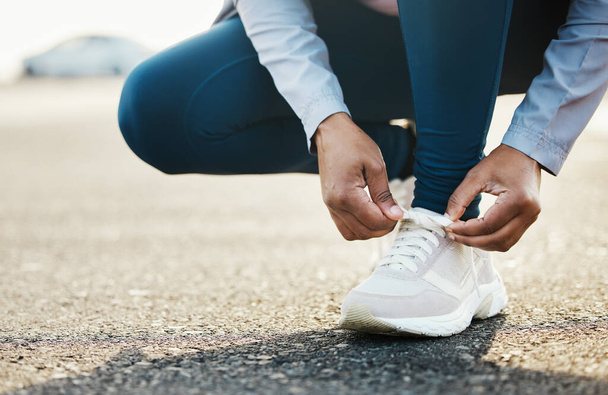 Αθλητισμός, closeup και γυναίκα γραβάτα παπούτσια υπαίθρια στο δρόμο για τρέξιμο προπόνηση στην πόλη. Γυμναστική, υγεία και μεγέθυνση της αθλήτριας που δένει τα κορδόνια της για άσκηση καρδιο για αγώνα ή μαραθώνιο - Φωτογραφία, εικόνα