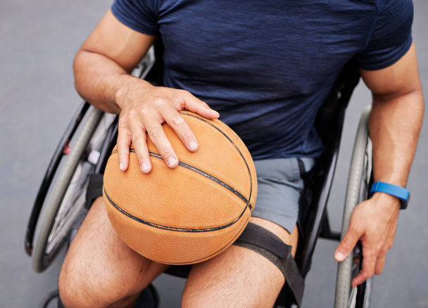Αμαξίδιο, μπάσκετ και αντρικό χέρι με εξωτερική αθλητική μπάλα για φυσική κατάσταση, προπόνηση και καρδιο. Άσκηση, χόμπι και κορυφαία άποψη του άνδρα με αναπηρία έτοιμη για παιχνίδι, προπόνηση και διασκέδαση ή ενεργό αγώνα. - Φωτογραφία, εικόνα
