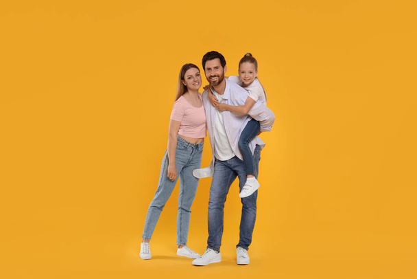Portrait of happy family on orange background - Photo, image
