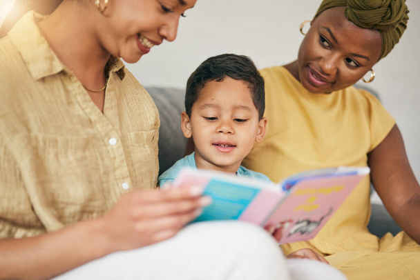Lectura, familia gay y niño con un libro en un sofá para el hogar para el conocimiento, la educación y el aprendizaje. Adopción, mujeres lesbianas o LGBT o padres y niños juntos en un salón con una historia para el tiempo de calidad. - Foto, Imagen