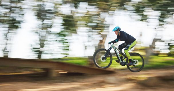 Bicycle, man and speed with motion blur in forest for sport, race or adventure in summer, woods or nature. Extreme fast cycling, person and action on trail, workout or challenge for fitness on bike. - Photo, Image