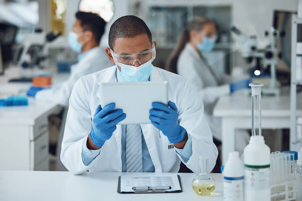 Man, tablet en gezichtsmasker in het wetenschappelijk laboratorium voor medisch virusonderzoek, geneeskunde en vaccinontwikkeling. Afrikaanse wetenschapper, persoon en technologie voor DNA-gezondheidszorg en beheersing van genetische ziekten. - Foto, afbeelding