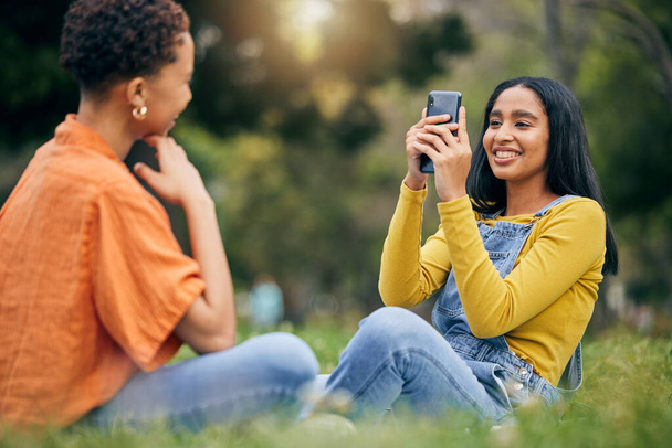 Phone, photography and women at a park relax, bond and having fun on the weekend together. Profile picture, smartphone and female friends in forest with photo, memory and social media post in nature. - Photo, Image