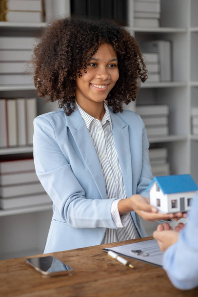 Una donna americana è un broker immobiliare per case e condomini, è un broker immobiliare che consiglia case ai clienti. Concetto di trading immobiliare. - Foto, immagini