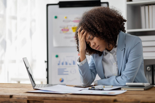 Američanka sedící v startupní společnosti, americká podnikatelka pracující v kanceláři, se stresujícím způsobem prohlíží finanční dokumenty a prodejní data, aby to shrnula, než se zúčastní setkání - Fotografie, Obrázek