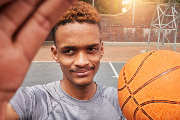Hombre africano, jugador de baloncesto y selfie retrato en la cancha para redes sociales, blog de fitness o entrenamiento partido vlog. Cara, pov o atleta con balón para ejercicio, entrenamiento y fotografía deportiva en juegos. - Foto, Imagen