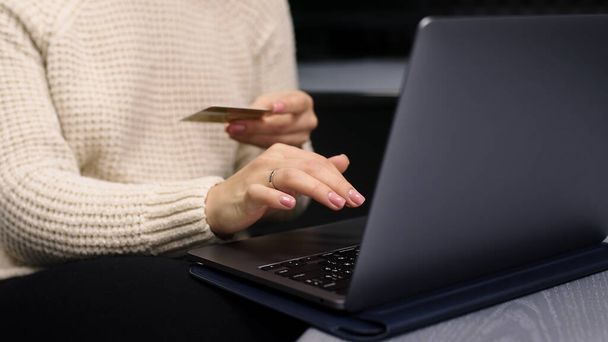 クレジットカードを持っている若い女性とオンラインショッピングのためにラップトップコンピュータを使用. - 写真・画像