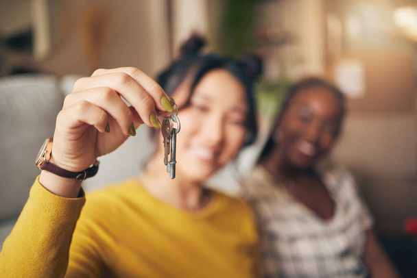 Hand, keys and new home or people moving in together for real estate investment. Rent, mortgage and loan closeup of women friends celebrate at apartment, property or house with a partner for freedom. - Photo, Image