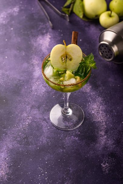 Cocktail alcoolisé pomme ou mocktail à la cannelle sur fond violet - Photo, image