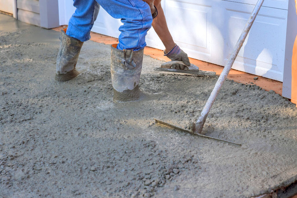 Concrete leveling workers on construction site with mix trowel leveling to concrete driveway - Photo, Image