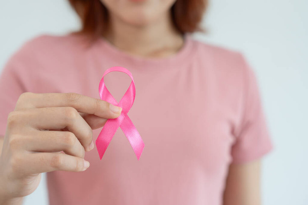 Жінка тримає інформацію про рожевий стрічковий рак молочної залози. Жіноча свідомість. Міжнародний день жінок і Всесвітній день раку. рак, символіка, охорона здоров "я, підтримка пацієнтів, своєчасний діагноз - Фото, зображення