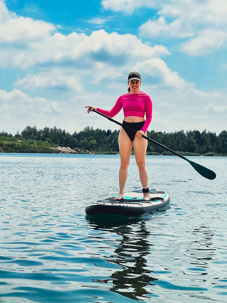 όρθια γυναίκα σε supboard δραστηριότητες καλοκαιρινής λίμνης νερού - Φωτογραφία, εικόνα