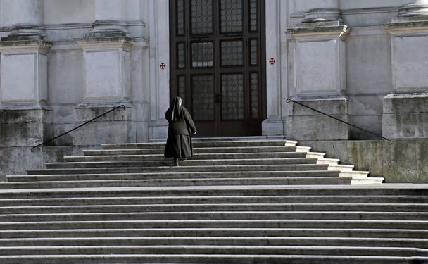 καλόγρια που ανεβαίνει τα σκαλιά της εκκλησίας - Φωτογραφία, εικόνα