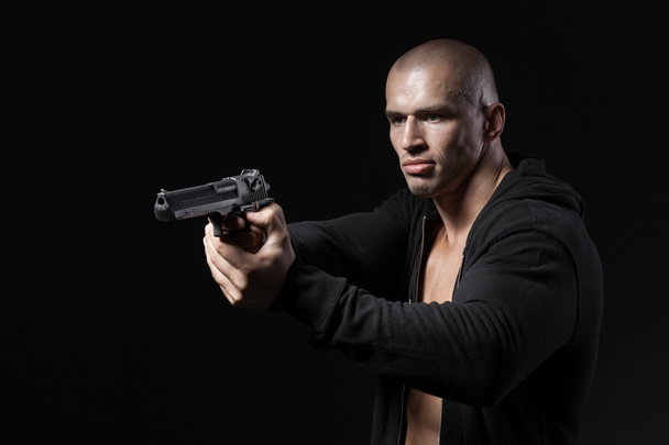 άνθρωπος που γυρίσματα όπλο που απομονώνονται σε μαύρο φόντο - Φωτογραφία, εικόνα