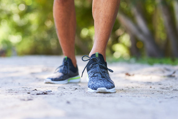 Cierre de zapatillas en el parque, hombre corriendo fitness al aire libre. Foto de alta calidad - Foto, imagen