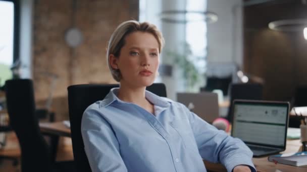 Portrait of confident businesswoman sitting empty modern office. Beautiful gorgeous lady boss looking camera attentively close up. Rich female business owner posing at workplace with laptop on table. - Footage, Video