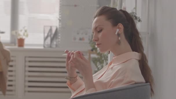 Mladá krásná běloška hromadí nehty na pracovišti v kanceláři - Záběry, video