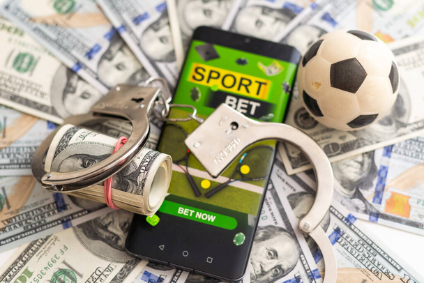 Telefon auf Dollarschein mit Fußball auf Rasenhintergrund, Geschäfts- und Sportkonzept. Hochwertiges Foto - Foto, Bild