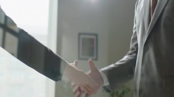 Προβολή μέσα από το γυάλινο τοίχο των πολυεθνικών επιχειρηματιών σε επίσημα ενδύματα χειραψία στο γραφείο - Πλάνα, βίντεο