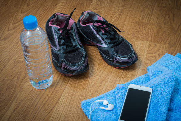 Sport equipment. Sneakers, water , earphones, smart phone - Fotografie, Obrázek