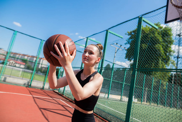 Giocatrice atletica femminile di basket che lancia una palla fino alla rete. - Foto, immagini