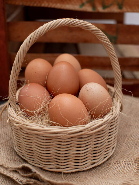 Cesto di uova fresche e uova di pollo con paglia essiccata. concetto di azienda biologica - Foto, immagini