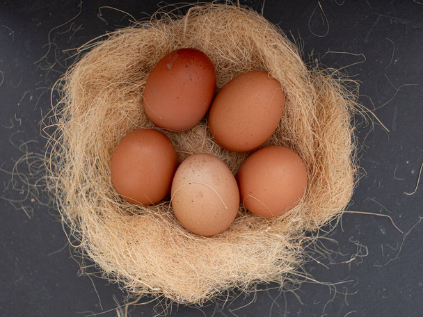 vista dall'alto di uova di pollo fresche su paglia secca concetto di azienda agricola biologica - Foto, immagini