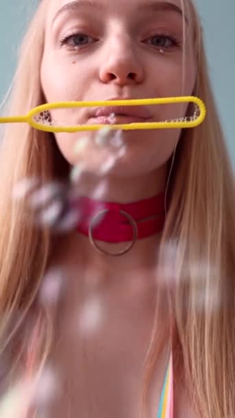 O rosto de uma menina vestida de forma inspirada em bonecas, brincando com bolhas de sabão. Imagens 4k de alta qualidade - Filmagem, Vídeo