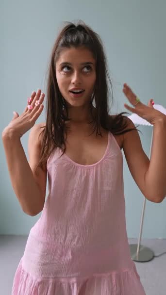 Uma menina em um vestido rosa, vestida em um estilo boneca-like, mostra seu olhar para a câmera. Imagens 4k de alta qualidade - Filmagem, Vídeo