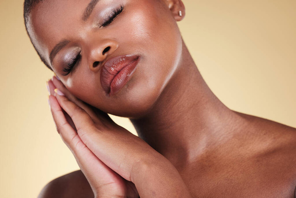 Black woman, makeup and face or beauty portrait in studio for skin care, glow and cosmetics. Headshot of african person or model with facial shine, dermatology and wellness on a beige background. - Photo, Image