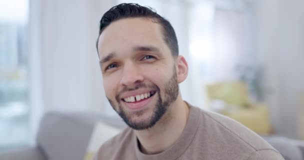 Happy, smile and face of a man in the living room of his modern apartment to relax on a weekend. Happiness, calm and portrait of a young male person from Brazil sitting on sofa in the lounge at home - Footage, Video
