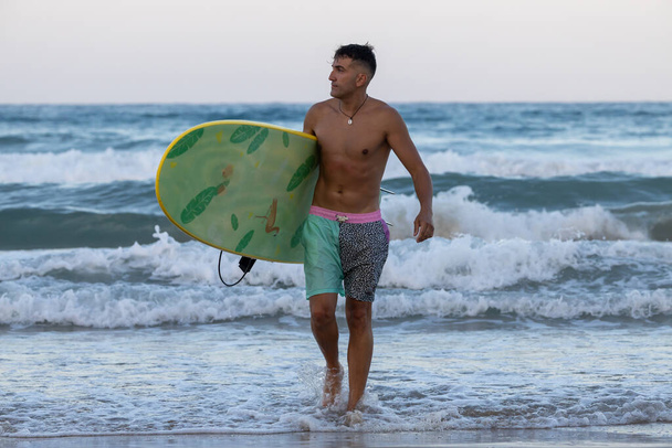 surfer on the beach with surfboard - Fotó, kép