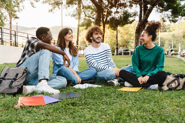 Studenci koledzy na trawie, zabawy razem w kampusie uniwersyteckim - Afroamerykanie młodzieży - Zdjęcie, obraz