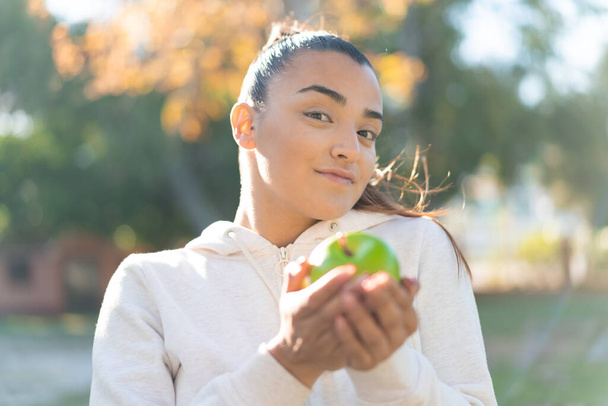 Jeune jolie femme sportive tenant une pomme - Photo, image