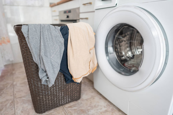 Одяг, що висить з кошика, готовий покласти їх у автоматичну пральну машину - Фото, зображення