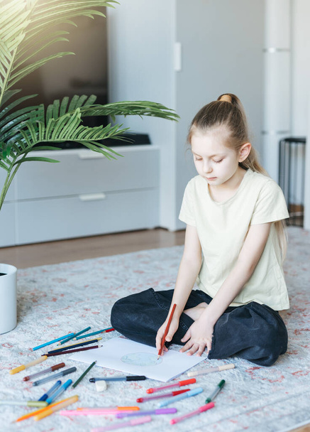 カラフルな鉛筆で自宅で子供の女の子の描画。生態学的概念地球を描く.  - 写真・画像