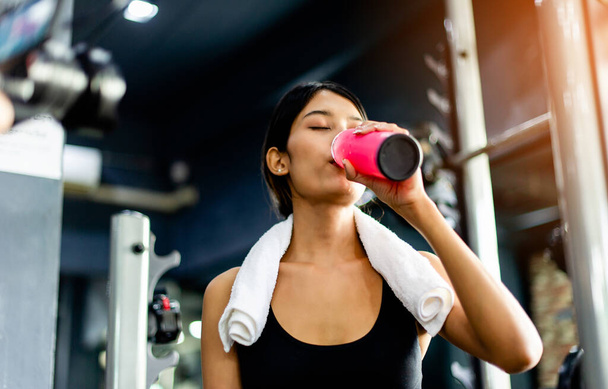 Пейте воду после тренировки и пота от напряженных упражнений. усталость от физических упражнений - Фото, изображение