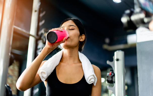 Drink water after exercising and sweating from strenuous exercise. tiredness from exercise - Photo, Image