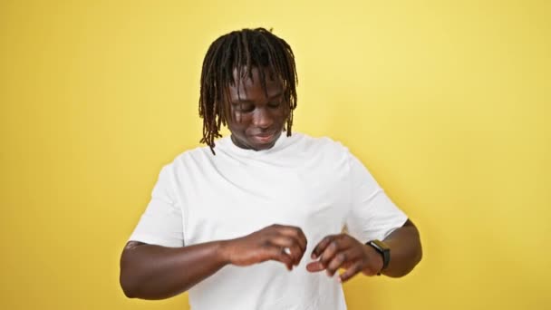 Afrikkalainen amerikkalainen mies hymyilee luottavainen tekee sydämen ele kädet yli eristetty keltainen tausta - Materiaali, video