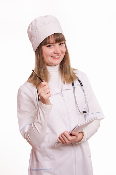 Медицинский работник в форме работы с ноутбуком и ручкой
 - Фото, изображение