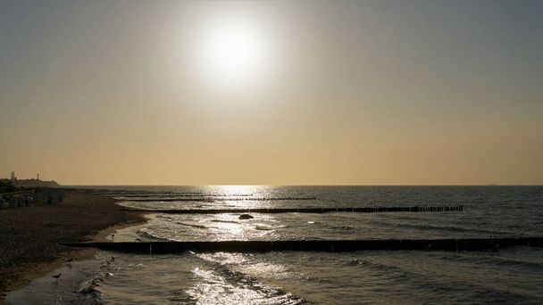  Pláž na německém pobřeží Baltského moře v blízkosti Kuehlungsborn se sluncem a zadní světlo                               - Fotografie, Obrázek