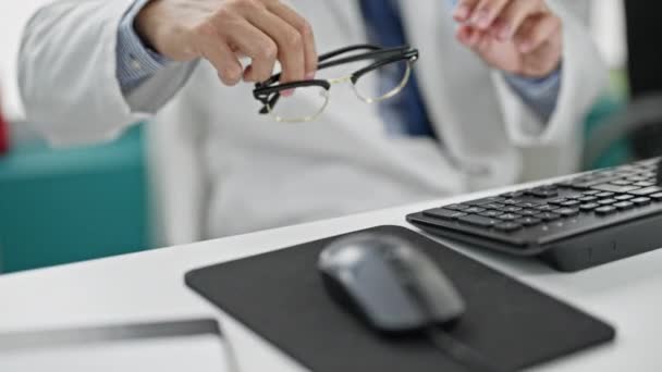 Молодий іспаномовний лікар використовує комп'ютер в окулярах у клініці - Кадри, відео